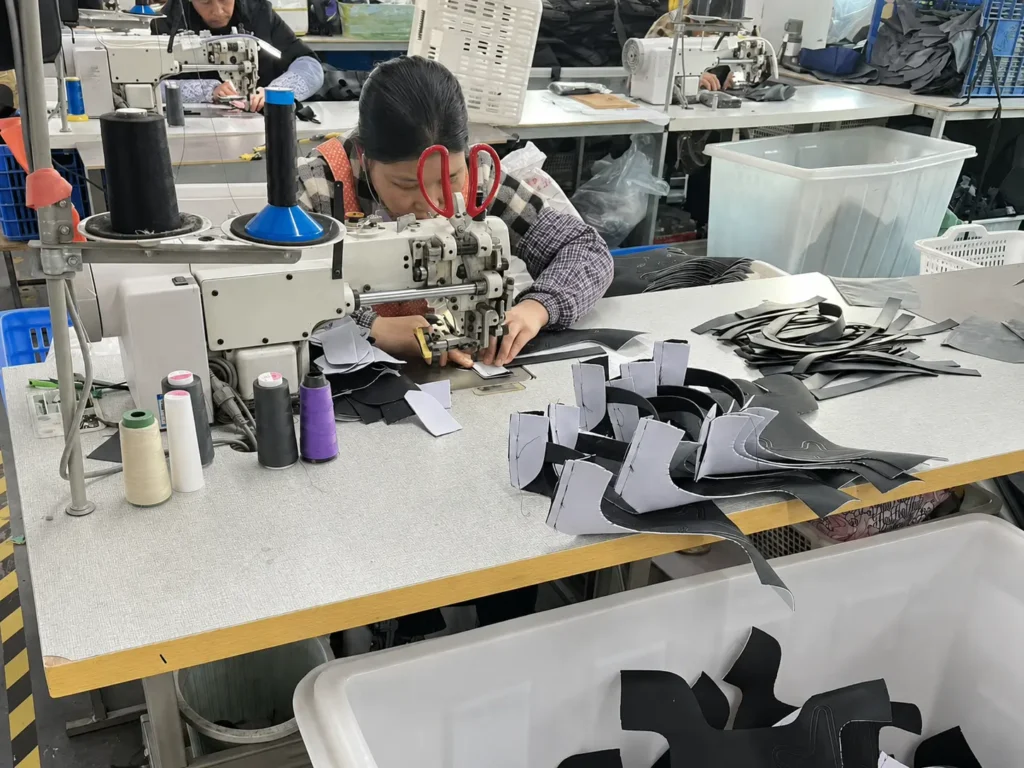 Worker sewing custom shoulder bag panels during bulk production